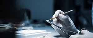 A lab worker processing a dental crown