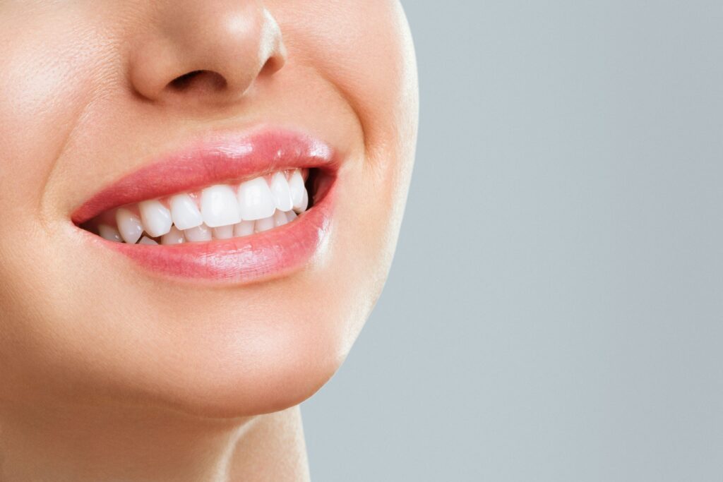 Nose-to-neck view of woman smiling with white teeth